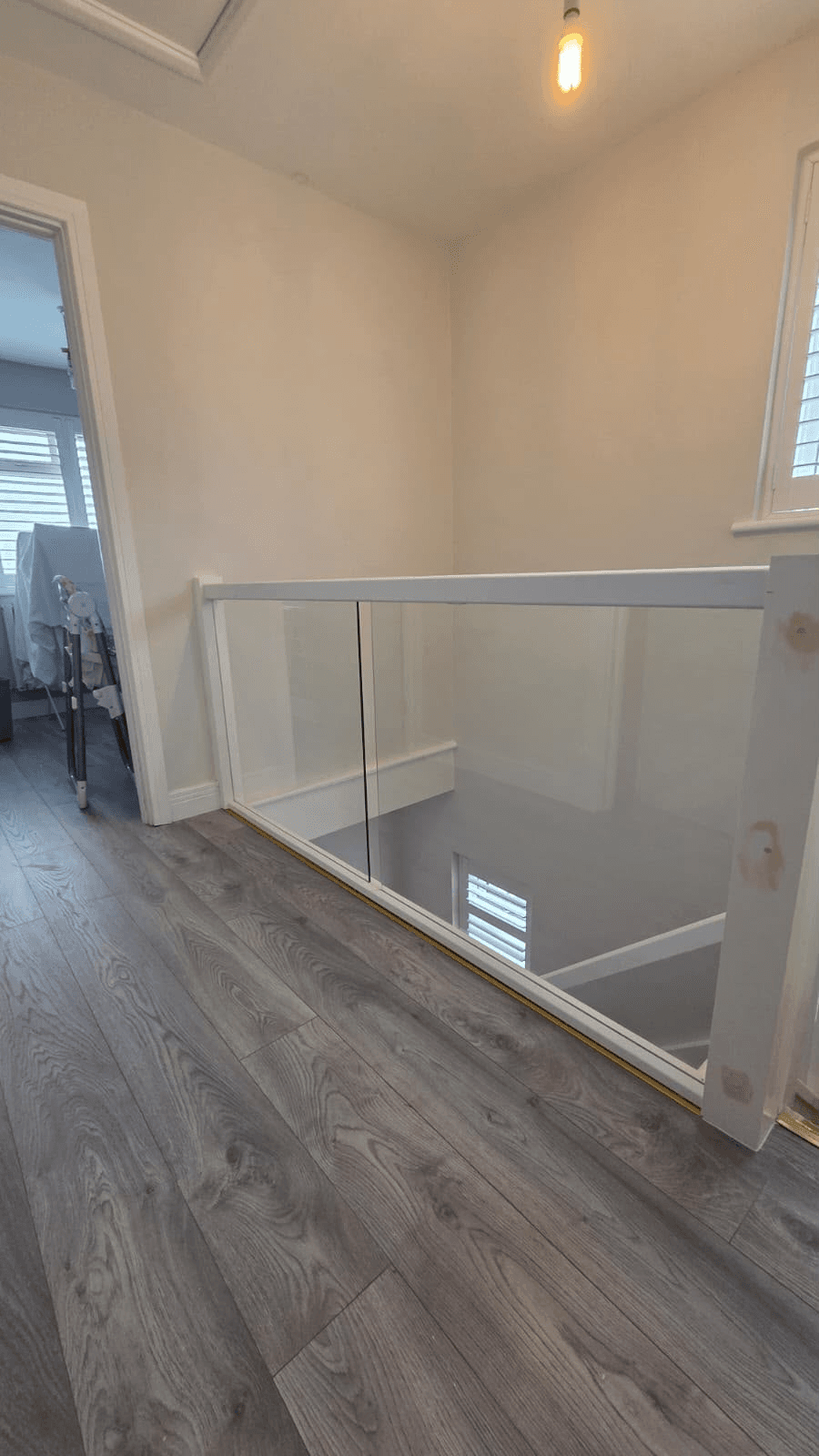 Glass panel balustrade on landing with timber handrail