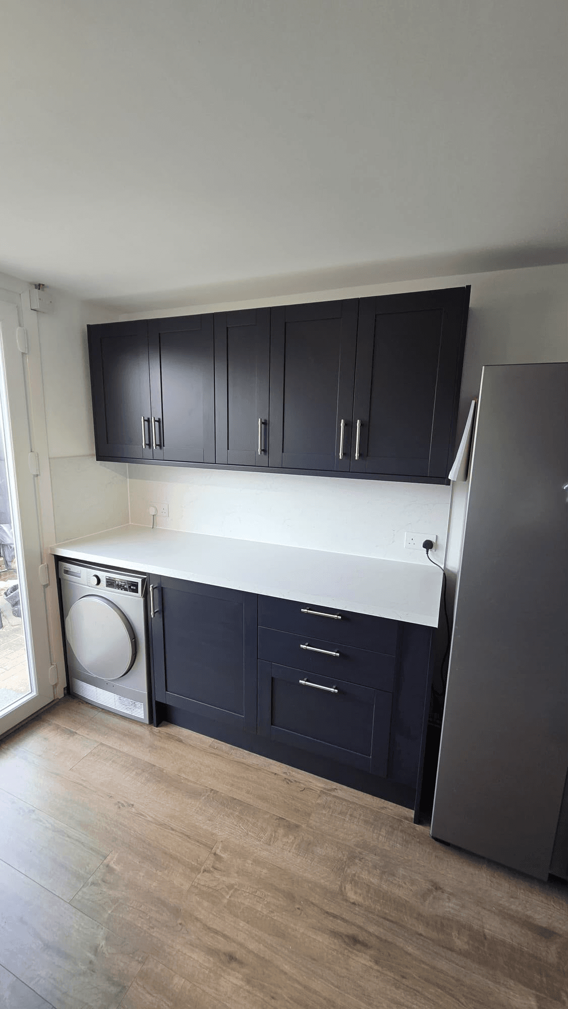 Navy kitchen utility area with washing machine